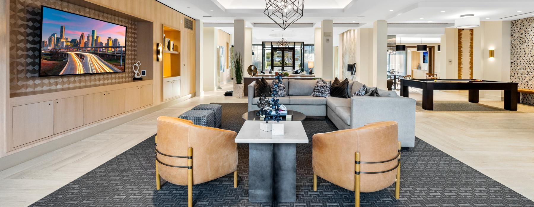 a lounge room with a tv a chandelier and a couch