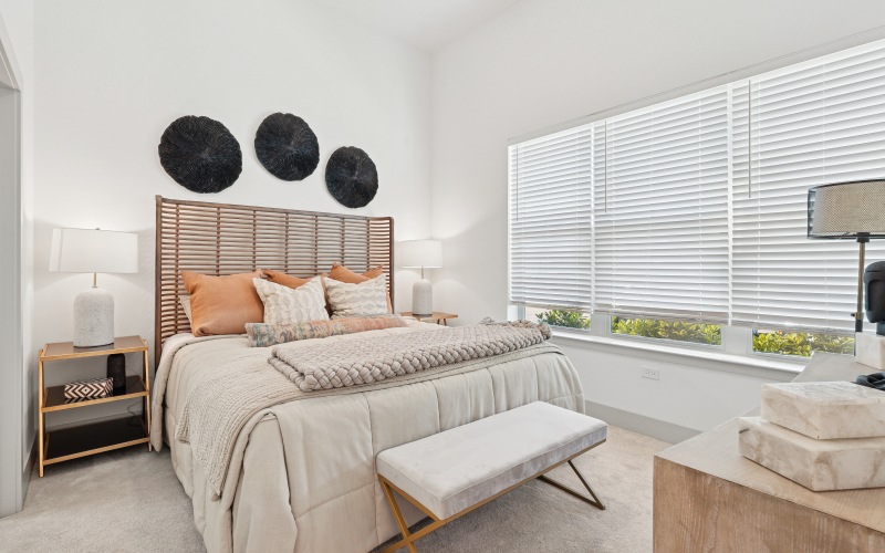 a bedroom with a bed and large windows