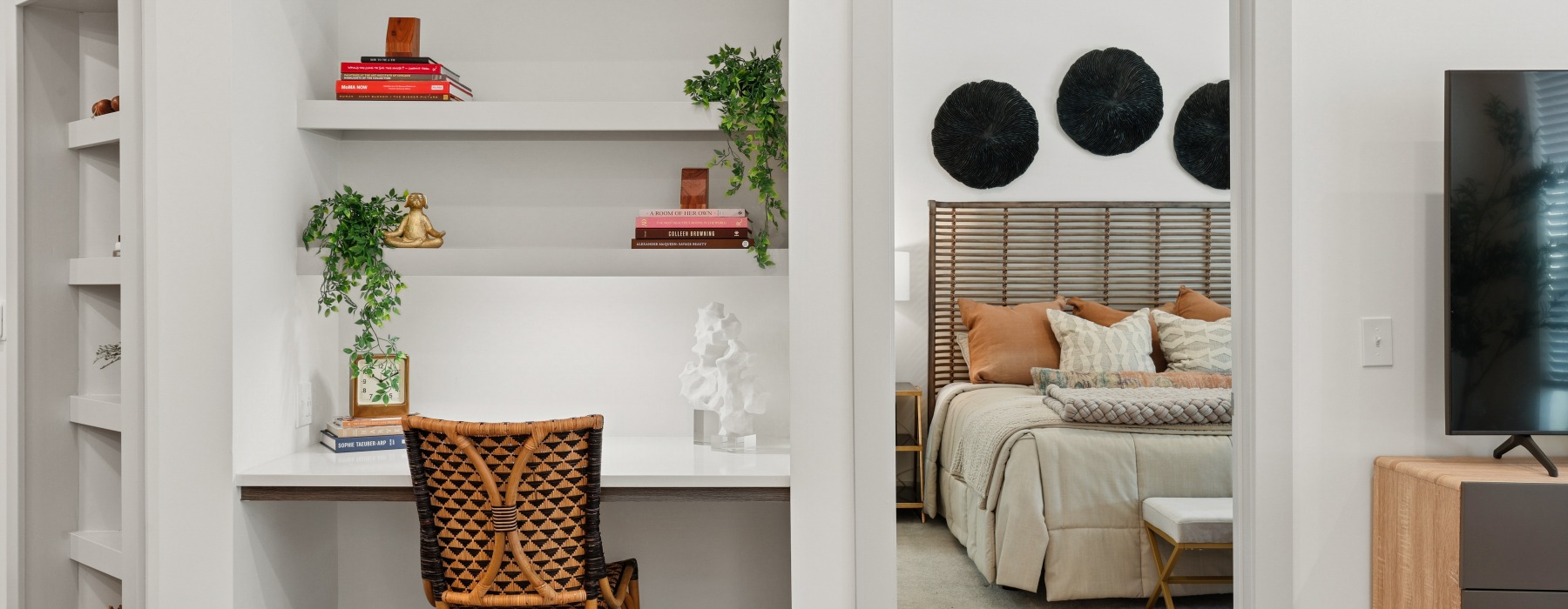 Model bedroom at Sagewell Hanover Apartments For Rent in Hanover, MA, featuring a nook with a chair and shelf.